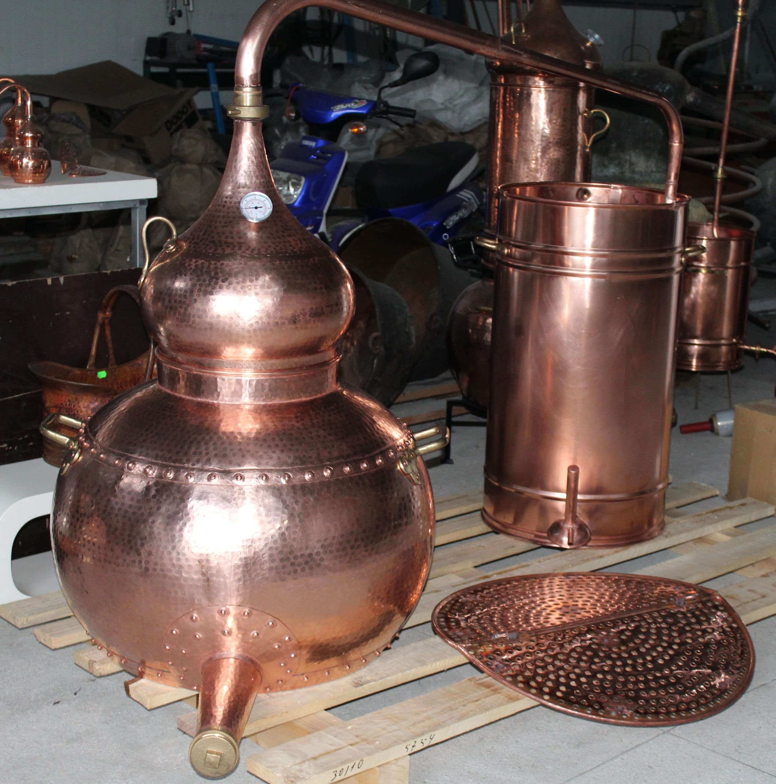 This Premium Copper Riveted alembic still is completely equipped with a copper pot, riveted union construction, a swan neck lid and a condensing recipient with serpentine coil This model is also equipped with a detachable brass locking system on the helmet lid that will facilitate storage when the alembic is not in use and also allows the connection of a refining lentil that can be purchased separately. Thermometer, drain pipe and sieve not included.